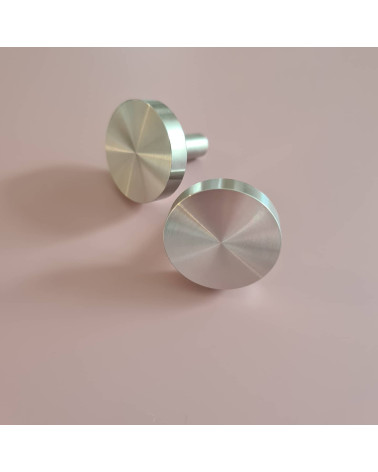 Tirador de mueble cromo pulido NENA M diseño colocados uno al lado del otro sobre una superficie plana