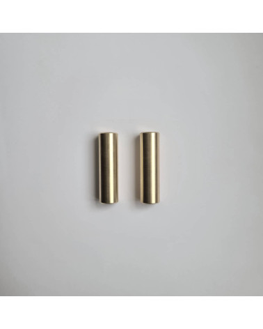 Tirador de mueble de latón SIV M diseño dispuestos en paralelo sobre una superficie gris
