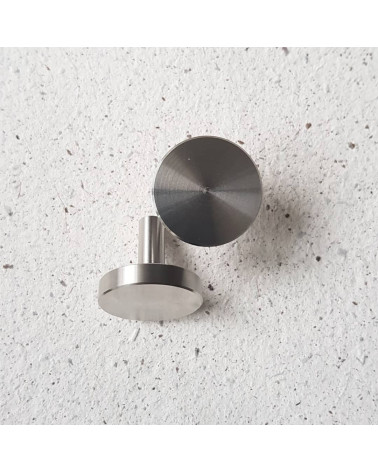 Tirador de mueble en cromo pulido NENA M diseño colocado sobre una superficie de cemento