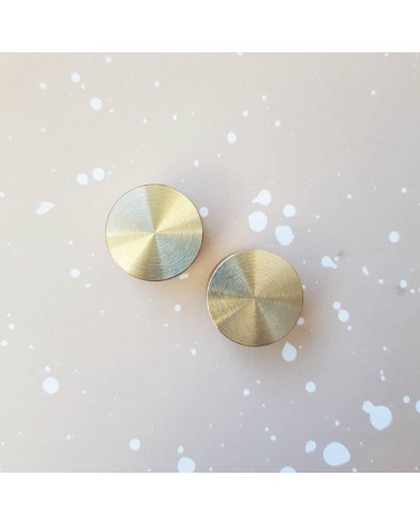 Tirador de mueble en oro mate TOVE diseño visto desde arriba colocado uno al lado del otro sobre una superficie clara con salpic
