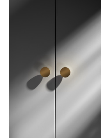 Botón de mueble dorado pulido LUNA M tirador de diseño vista frontal montado en un mueble