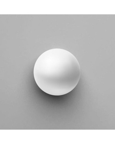 Botón de mueble blanco ODETE tirador de diseño vista desde arriba colocado sobre una superficie gris