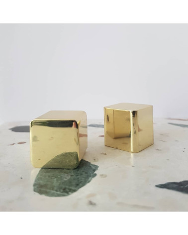 Botón de mueble en latón LANA S tirador de diseño colocados sobre una superficie de piedra con motivo