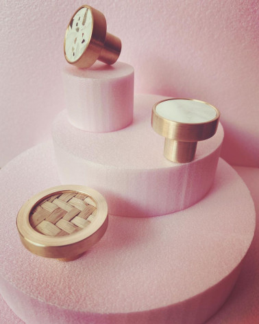 Tirador de mueble en latón y Terrazzo tirador de diseño destacado sobre un expositor rosa