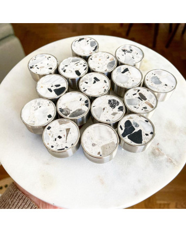 Tiradores de mueble en latón y Terrazzo de diseño apilados sobre una superficie de mármol