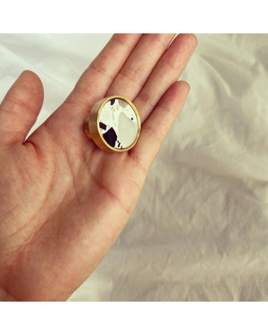 Tirador de mueble en latón y Terrazzo tirador de diseño presentado sobre una mano