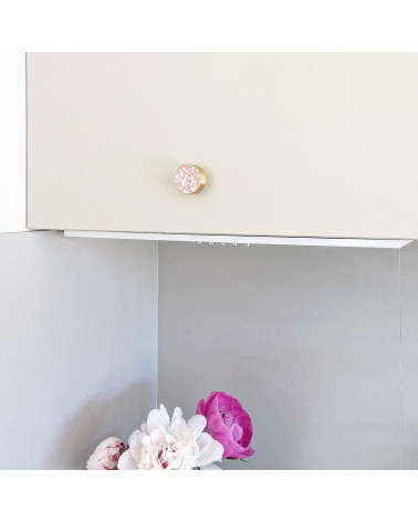 Tirador de mueble en latón y Pink Terrazzo tirador de diseño instalado en un mueble con flores rosas en la parte inferior