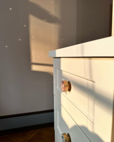 Tirador de mueble en latón y Pink Terrazzo tirador de diseño instalado en un cajón bajo luz natural