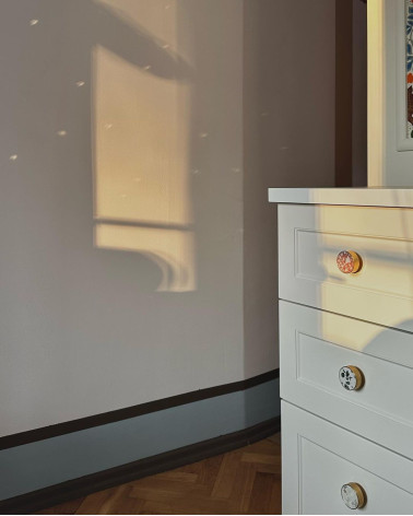 Botón de mueble en latón y Pink Terrazzo tirador design visto en ángulo iluminado por los rayos del sol