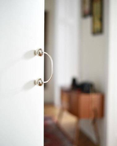 Tirador de mueble en latón 10 tirador design fijado en una puerta con fondo desenfocado