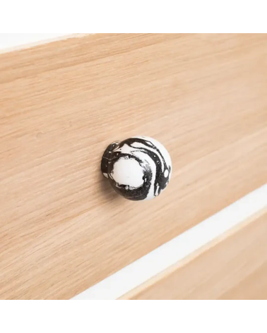 Botón de mueble en madera de haya negro tirador design visto de lado sobre una placa de madera