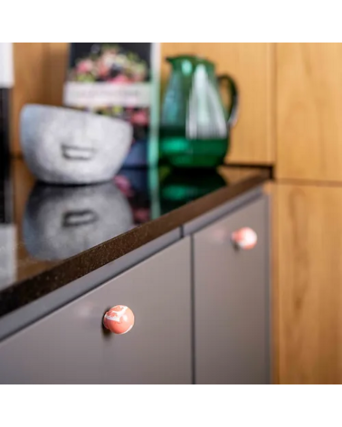 Botón de mueble de madera de haya rojo cereza, tirador de diseño instalado en una puerta de mueble de cocina