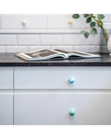 Botón de mueble de madera de haya verde intenso, tirador de diseño visto de frente instalado en una cómoda
