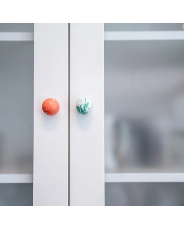 Botón de mueble de madera de haya verde intenso, tirador de diseño fijado en un armario con cristal