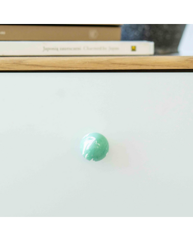 Botón de mueble de madera de haya verde intenso, tirador de diseño visto de frente montado en un mueble