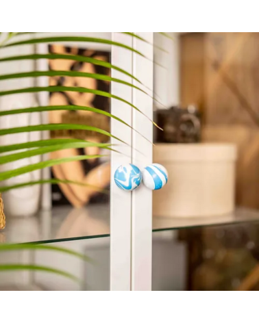 Botón de mueble de madera de haya Azul Azur, tirador de diseño visto de frente instalado en una puerta de cristal