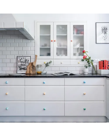 Botón de mueble de madera de haya Azul Azur, tirador de diseño visto de frente instalado en el primer cajón de un mueble