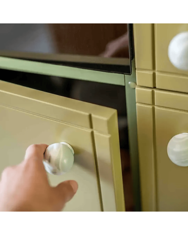 Botón de mueble de madera de haya Mistel, tirador de diseño fijado en una puerta abierta sostenida por una mano