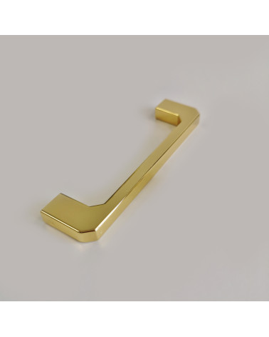 Tirador de mueble dorado pulido CAMPANA diseño decorativo colocado sobre una superficie gris
