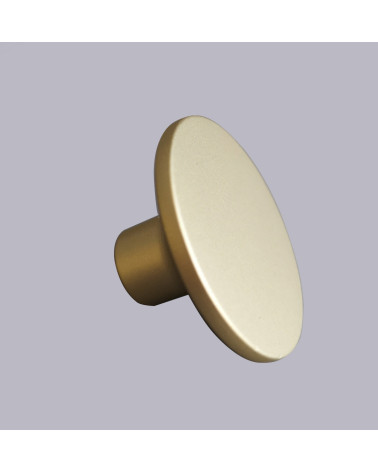 Botón de mueble dorado mate ASTRO tirador de diseño sobre fondo gris