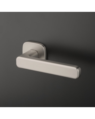Tirador de puerta níquel satinado IXIA diseño fijada sobre un fondo oscuro