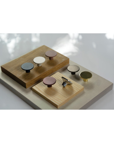 Botón de mueble ASTRO tirador de diseño dispuesto sobre placas de madera