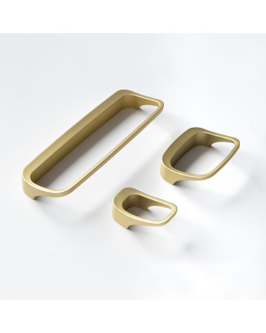 Botón de mueble oro mate LAGO tirador de diseño colocado sobre una superficie blanca