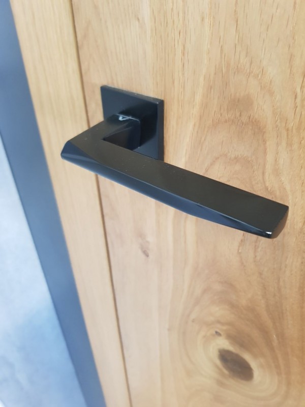 tirador negro de diseño en una puerta de madera