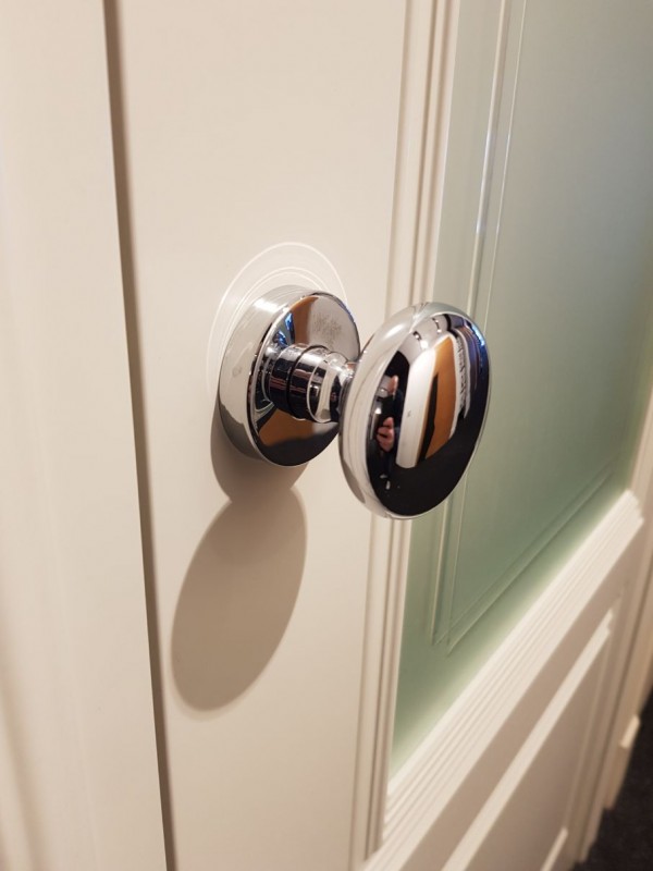 botón de puerta sobre una puerta blanca de vidrio
